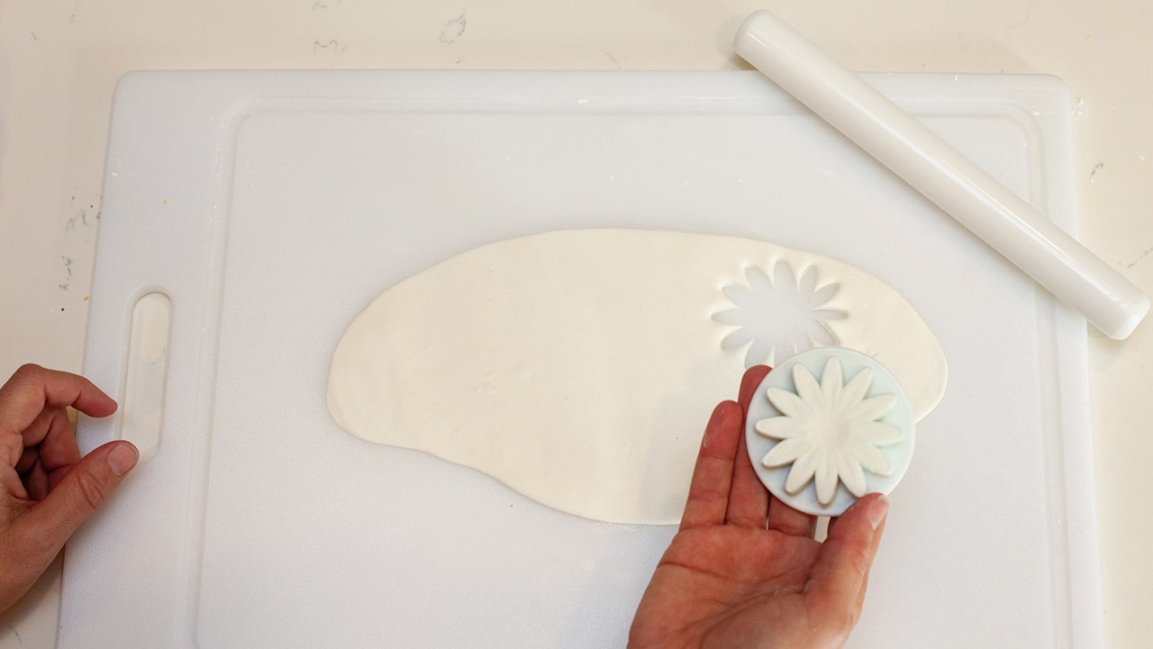 cutting out daisy shapes using fondant cutter